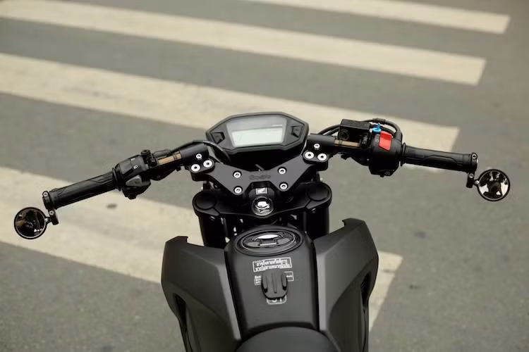 Bên cạnh phuộc trước, chảng 3 trước của chiếc xe cũng được thay hoàn toàn bằng bộ nhôm CNC của hãng Composimo ở Mỹ, kèm theo cặp tay clip-on thể thao. Ở cuối mỗi bên tay lái là cặp gương chiếu hậu mini. Đồng hồ điện tử nguyên bản của chiếc xe côn tay cỡ nhỏ được giữ nguyên.