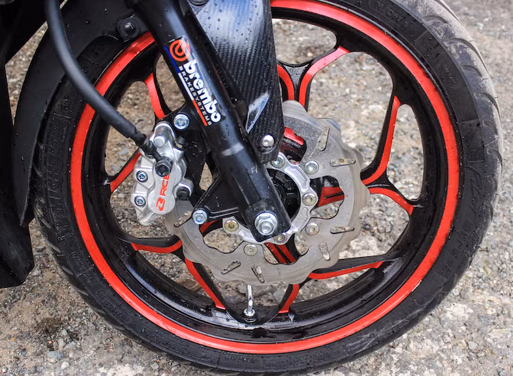 Điều dễ nhận ra đó là bộ mâm nguyên bản đặc trưng của Winner đã bị thay thế bởi mâm Asio đã quá quen thuộc với người chơi xe. Bên cạnh việc lên mâm, lốp trước cũng đã được nâng cấp lên loại Michelin Pilot Sport 110/70/17, đồng thời hệ thống phanh được thay thế với đĩa kiểng và heo Racing Boy.