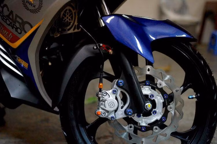 Trong đó, "dàn chân" của chiếc xe đã được biker này khá chú trọng với việc thay cặp mâm 6 cánh của mẫu xe 2 kỳ Yamaha 125ZR, kèm theo hệ thống phanh trước mới với đĩa Galfer và heo Brembo 2 pis đối xứng kèm pát nhôm CNC.