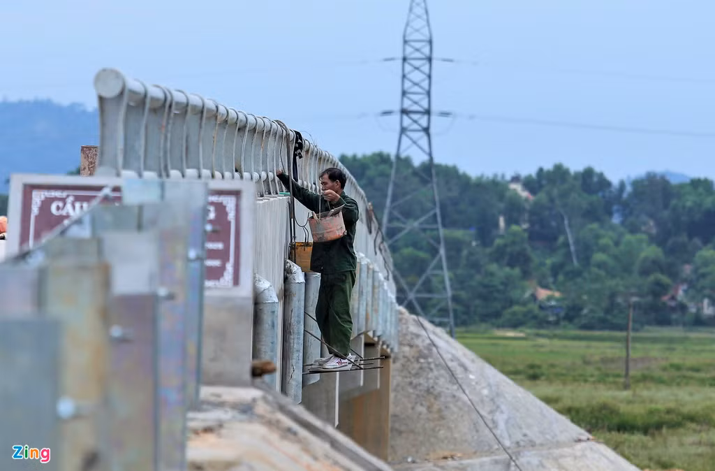 Đến nay, cầu đã vượt tiến độ. Trong ảnh, công nhân đang hoàn thiện hệ thống lan can, các rãnh thoát nước của cầu.