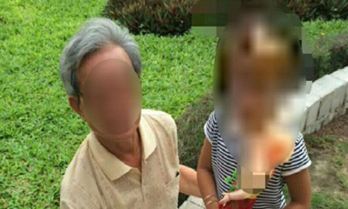 Ông Thế đang ngồi với một bé gái khác ở sân chung cư.