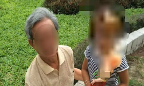 Ông Thế đang ngồi với một bé gái khác ở sân chung cư.