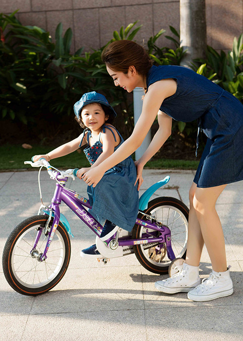 Bé Na dường như rất thích thú với việc tập đi xe đạp. 