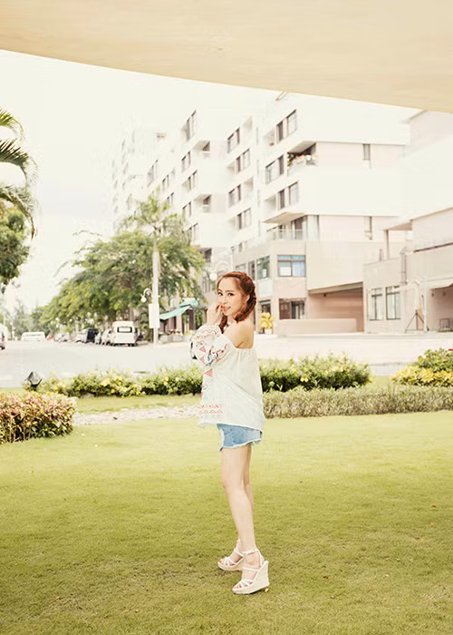 Bà xã Doãn Tuấn khéo léo phối áo trễ vai với quần short jeans và sandal đế xuồng tông màu trắng. 