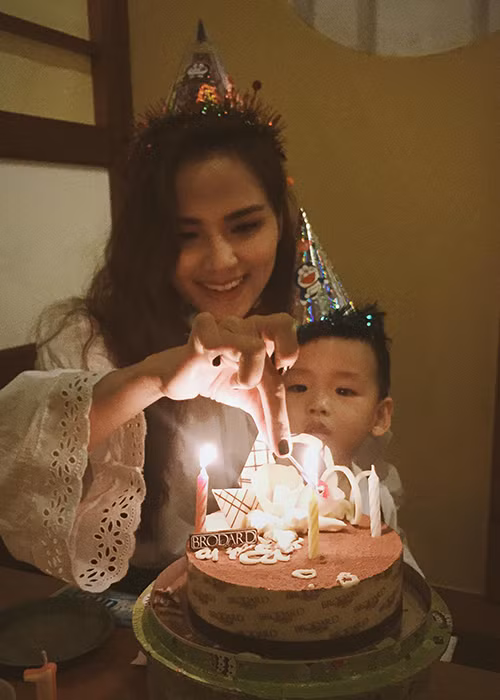 Trong tiệc sinh nhật, Hoa hậu Thế giới người Việt Nam 2010 và cậu quý tử diện trang phục tông trắng.