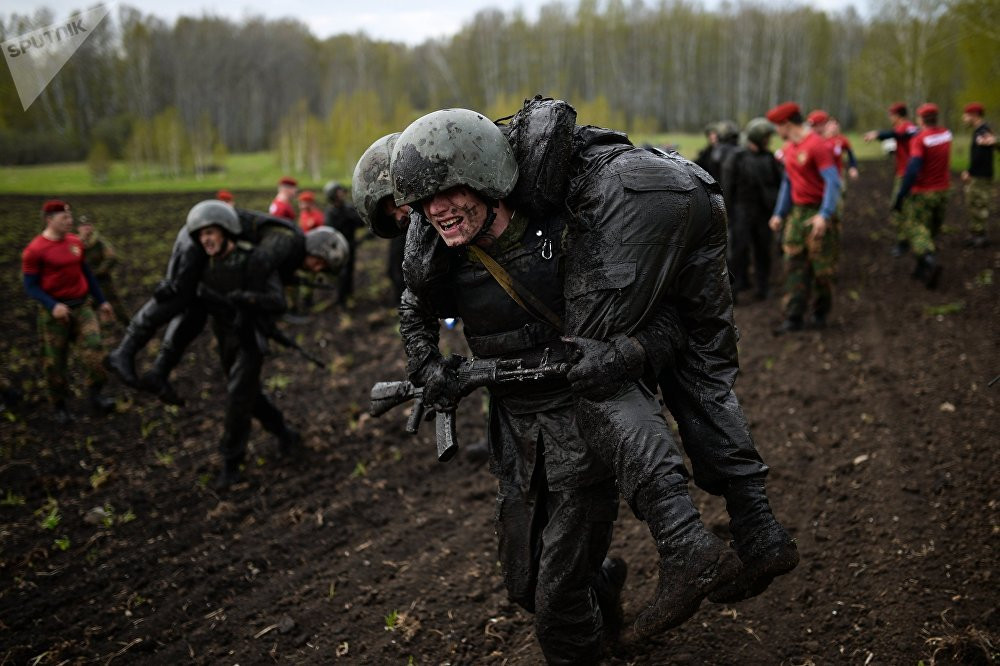 Hay thay phiên nhau cõng đồng đội về đích ở những trăm mét cuối cùng trên thao trường. Nguồn ảnh: Sputnik.