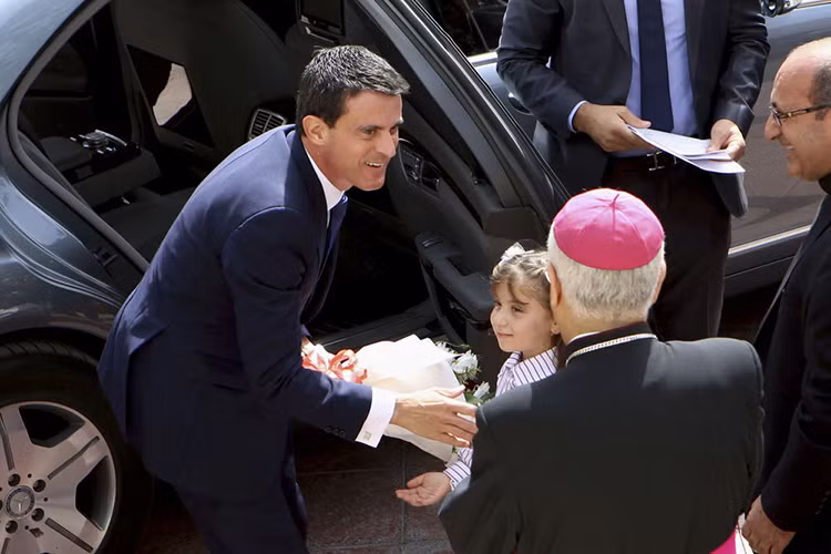 Thủ tướng Pháp Manuel Valls nhận bó hoa từ một bé gái trong chuyến thăm nhà thờ Công giáo ở Amman, Jordan, năm 2015. Ảnh: Sputnik.