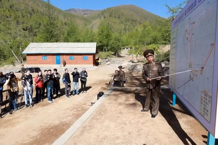 Một quan chức Triều Tiên đang giải thích quy trình và quá trình phá dỡ bãi thử hạt nhân Punggye-ri.