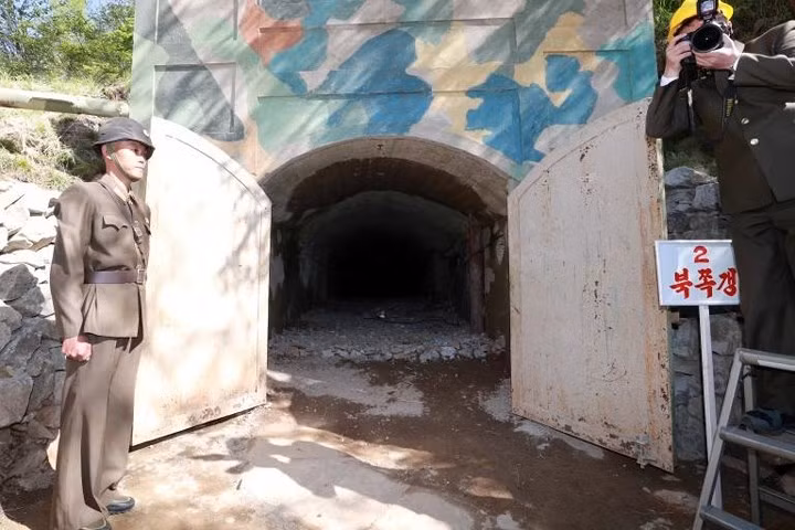 Một người lính Triều Tiên đứng gác phía trước đường hầm thứ 2 của bãi thử hạt nhân Punggye-ri trước khi bị đánh sập bằng thuốc nổ.