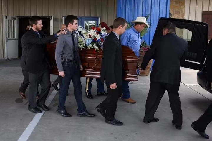 Quan tài mang thi hài cậu bé Christian Riley Garcia được đưa ra xe tang sau lễ truy điệu.