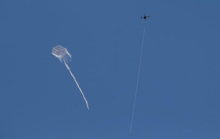 Một máy bay không người lái Israel (bên phải) đang cố bắn hạ con diều của người biểu tình Palestine ở phía đông thành phố Gaza.