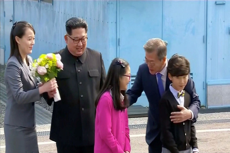 Lãnh đạo Triều Tiên Kim Jong-un và em gái Kim Yo-jong trong cuộc gặp Tổng thống Hàn Quốc Moon Jae-in tại Bàn Môn Điếm, Hàn Quốc, năm 2018. Ông Kim cũng được tặng một bó hoa nhỏ từ các em nhỏ Hàn Quốc. Ảnh: Sputnik.