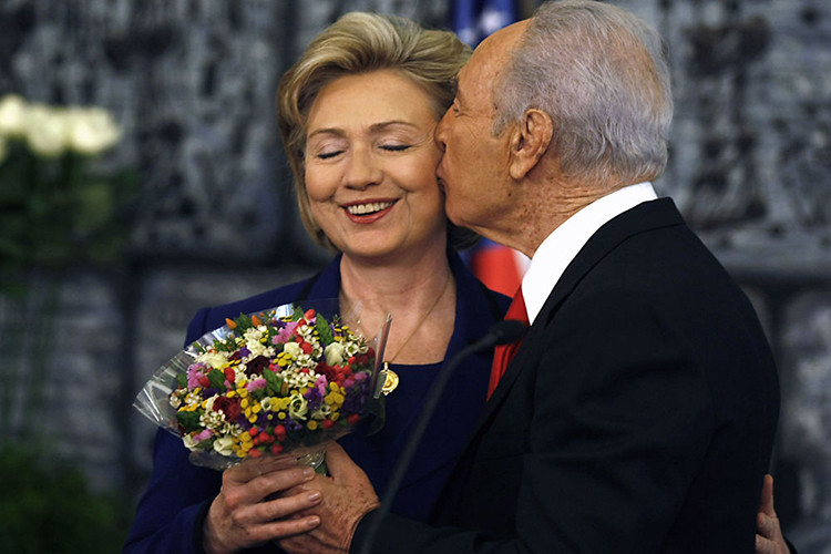 Cựu tổng thống Israel Shimon Peres ôm hôn Ngoại trưởng Mỹ Hillary Clinton, tặng bà bó hoa sau cuộc họp báo chung ở Jerusalem, năm 2009. Ảnh: Sputnik.