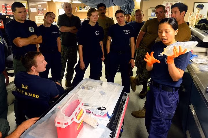 Hạ sĩ quan Kim Nguyen, chuyên viên y tế, đang huấn luyện cho một đội lặn của tuần duyên và hải quân.