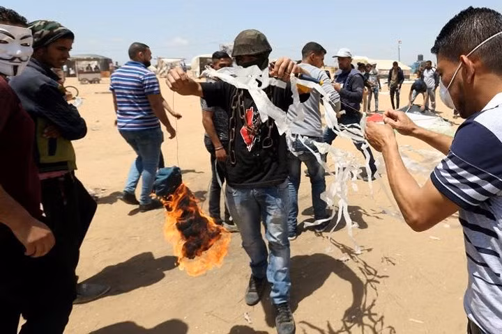 Người biểu tình Palestine chuẩn bị châm lửa lên một con diều trước khi thả cho nó bay về phía Israel trong cuộc biểu tình chống Israel ở biên giới Israel-Gaza vào ngày 11/5.