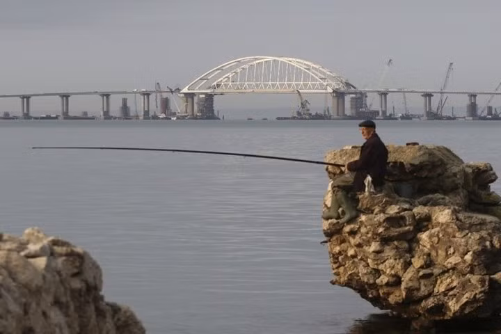 Hình ảnh một nam giới câu cá gần khu vực Vòm của cầu Crimea bắc qua eo biển Kerch. Ảnh: SCMP.