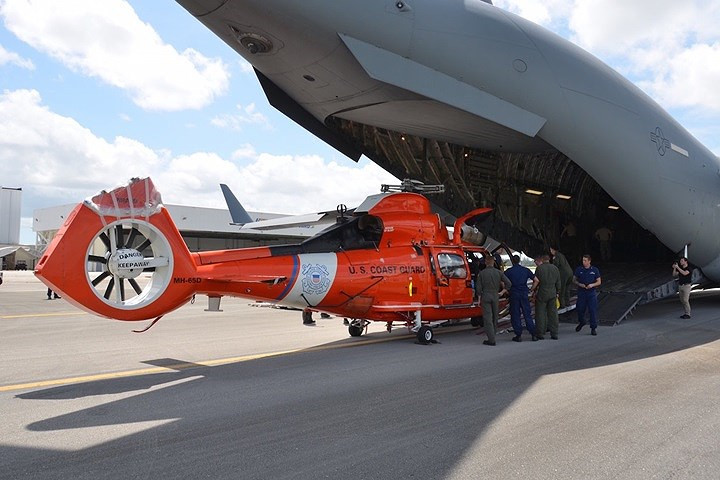 Lực lượng tuần duyên Mỹ dỡ máy bay trực thăng MH-65 Dolphin khỏi máy bay vận tải C-17 của Không quân Mỹ.