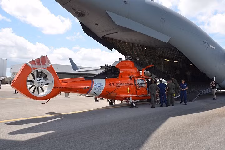Lực lượng tuần duyên Mỹ dỡ máy bay trực thăng MH-65 Dolphin khỏi máy bay vận tải C-17 của Không quân Mỹ.