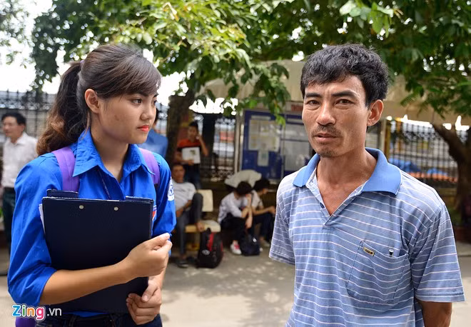 Ông Đinh Văn Anh (TP Ninh Bình) được sinh viên tình nguyện tư vấn trước khi rút hồ sơ. Con trai ông được 21,25 điểm và mong muốn nộp hồ sơ vào ĐH Giao thông Vận tải.