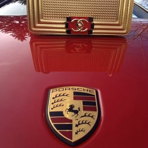 Túi xách Chanel đặt trên nắp capô xe Porsche cùng tông màu.