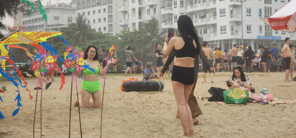 Trên bờ, nhiều du khách lựa chọn chụp ảnh, check-in, lưu giữ những bức hình kỷ niệm.