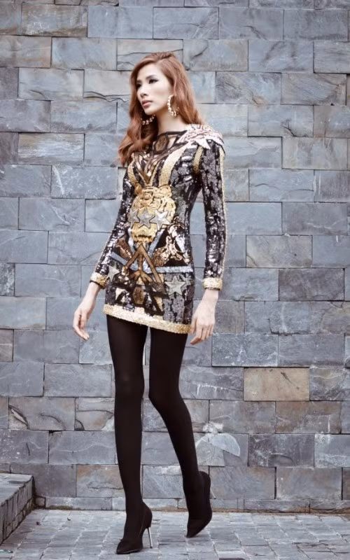 Đến tập 2, cô nàng siêu mẫu lại tiếp tục chơi trội khi diện tất đen để che phần nhược điểm chân gầy gò của mình. Dù cô có tiết chế lại, diện một chiếc váy ôm nhưng họa tiết quá nhiều khiến Hoàng Thùy trở thành một khúc gỗ di động không hơn không kém. Ảnh: Vietbao.