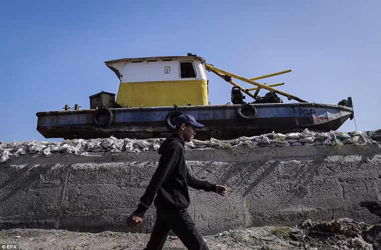 Một con thuyền neo đậu trên bức tường biển ở Muara Baru. Ảnh: EPA.