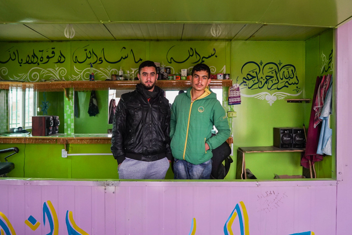 Ali (trái), 20 tuổi, và em trai Yousel. Ali đã được một tổ chức phi chính phủ dạy nghề cắt tóc, sau đó, anh đã mở một hiệu cắt tóc riêng trong khu trại tị nạn này.