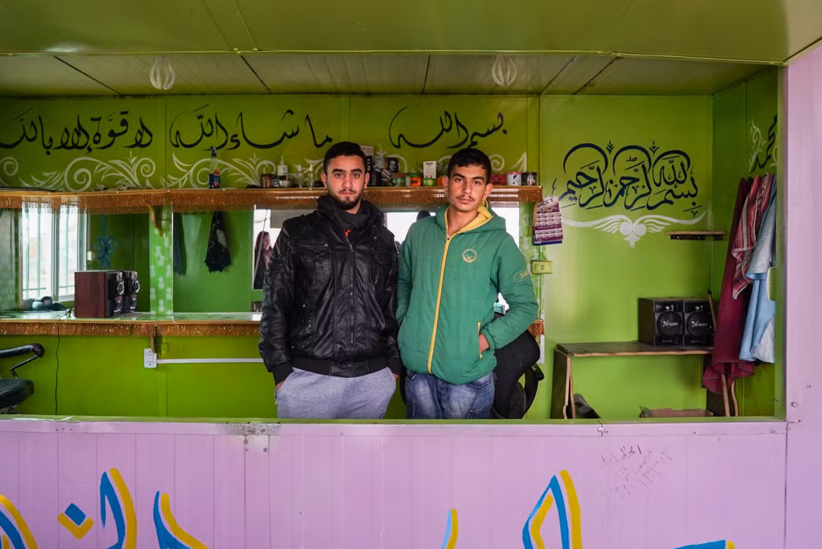 Ali (trái), 20 tuổi, và em trai Yousel. Ali đã được một tổ chức phi chính phủ dạy nghề cắt tóc, sau đó, anh đã mở một hiệu cắt tóc riêng trong khu trại tị nạn này.