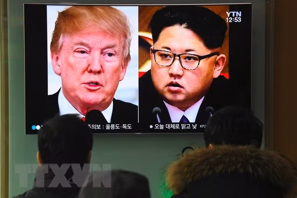 Người dân theo dõi hình ảnh Tổng thống Mỹ Donald Trump (trái) và nhà lãnh đạo Triều Tiên Kim Jong-un trên truyền hình ở Seoul (Hàn Quốc) khi truyền thông đưa tin về khả năng diễn ra cuộc gặp lịch sử Mỹ-Triều.