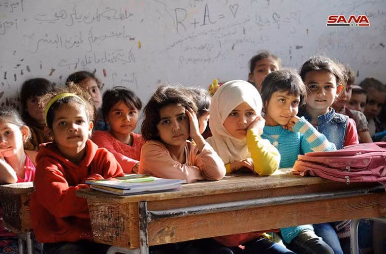 Các em nhỏ ngồi chen chúc trong một lớp học ở Đông Ghouta. Ảnh: AMN/SANA.