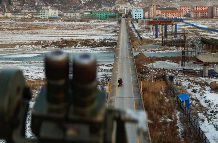 Hai người phụ nữ đi qua cây cầu từ Namyang ở Triều Tiên sang thị trấn Đồ Môn ở Trung Quốc.