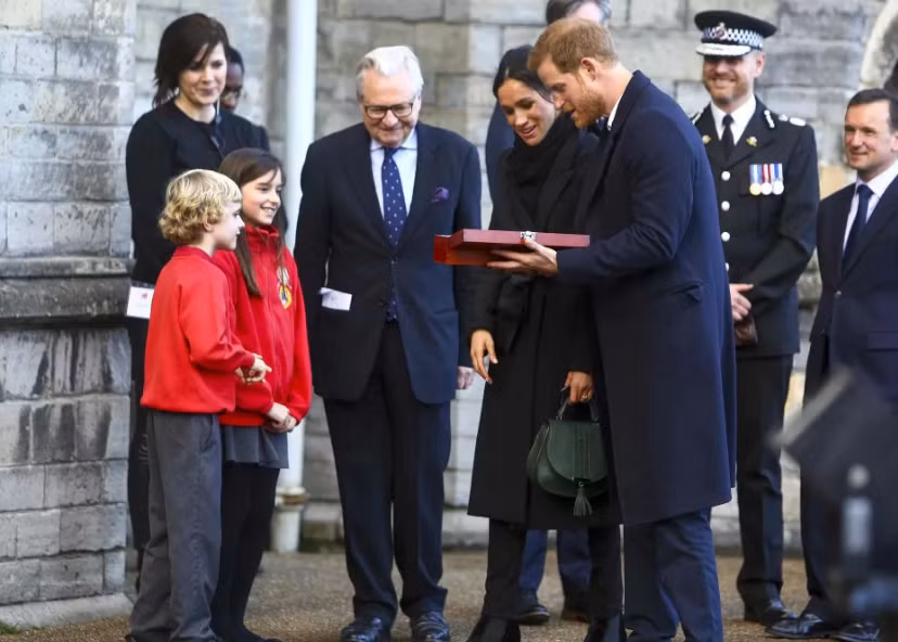 Harry Smith và Meghan Taylor, hai em nhỏ đến từ trường Tiểu học Marlborough, tặng quà cưới cho cặp đôi Harry-Markle khi hai người tới thăm ngôi trường này hôm 18/1/2018.