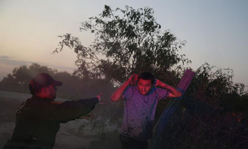 Nhân viên tuần tra biên giới Sergio Ramirez bắt giữ một di dân vượt biên trái phép từ Mexico vào Mỹ.