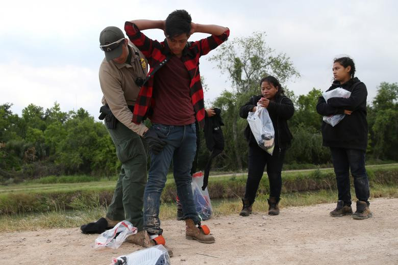 Nhân viên tuần tra biên giới Mỹ khám xét một di dân.