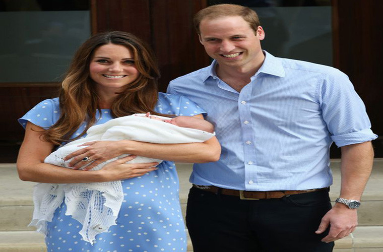 Công nương Kate Middleton bế Hoàng tử nhí George khi đứng cạnh chồng, Hoàng tử William, tại Lindo Wing năm 2013.