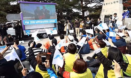Rất đông người dân Hàn Quốc vẫy cờ thống nhất khi theo dõi cuộc hội đàm thượng đỉnh Hàn-Triều qua màn hình lớn ở thành phố Paju ngày 27/4. Ảnh: AP.