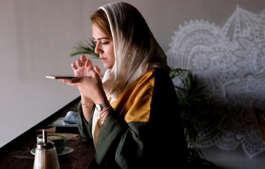 Amirah xem điện thoại khi ngồi trong quán cà phê yêu thích của cô.