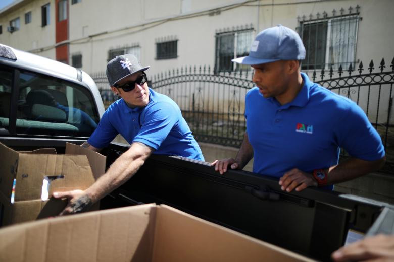 Kris Toriz (trái) và Brandon Ladell chuẩn bị phân phát đồ ăn cho những người vô gia cư ở Los Angeles.