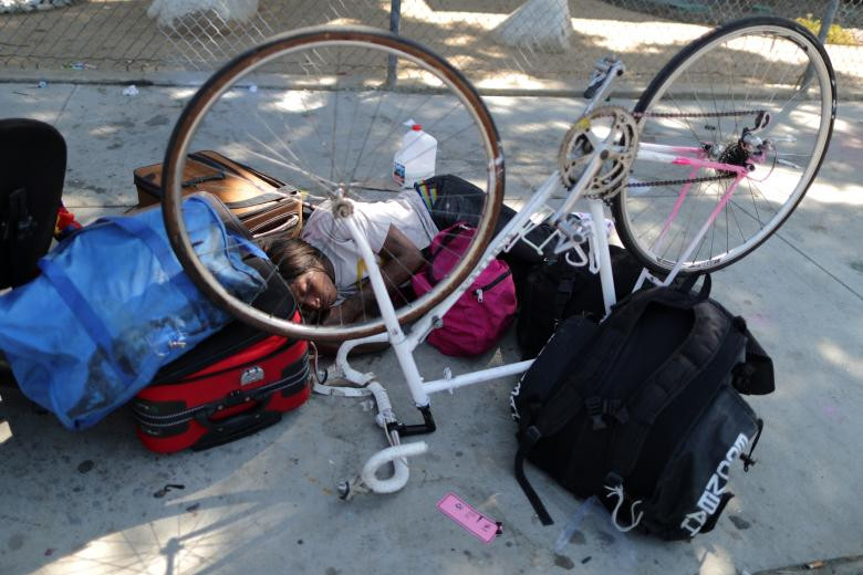 Người phụ nữ nằm ngủ giữa đống đồ đạc ngổn ngang trên đường phố Los Angeles.