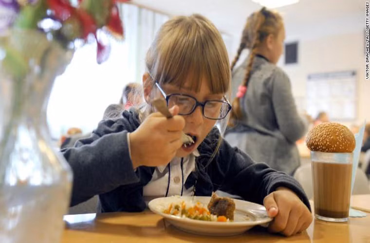 Tại một ngôi trường ở làng Kolno, Belarus, bữa trưa của học sinh gồm hai món chính là thịt nghiền và rau, ngoài ra còn có bánh sữa nóng và bánh mì. (Nguồn: CNN)