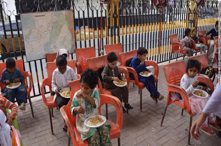 Các em học sinh ăn món truyền thống trong giờ ăn trưa tại Trường Karachi Footpath ở tỉnh Sindh, Pakistan. Theo CNN, ngôi trường này cung cấp bữa ăn miễn phí cho toàn bộ học sinh.