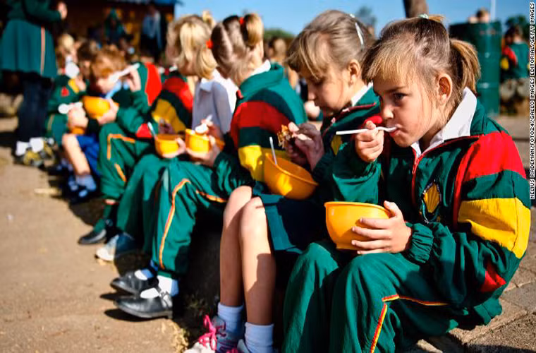 Học sinh ngồi ăn trưa tại Trường Tiểu học David Brink ở Rustenburg, Nam Phi.