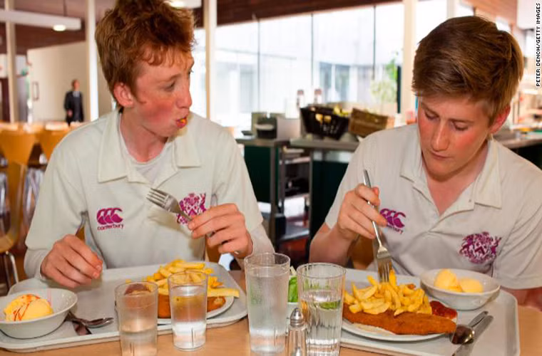 Hai nam sinh ăn bữa trưa, gồm cá và khoai tây chiên, tại căng tin của trường tư Fettes ở Edinburgh, Scotland.