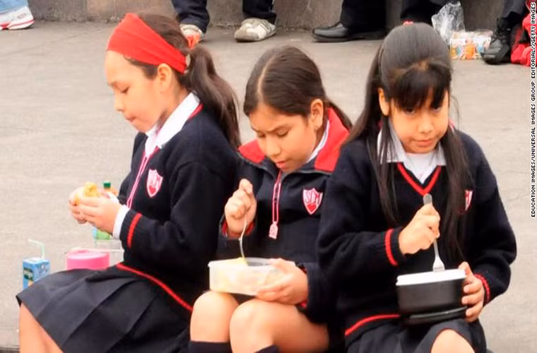 Các em nữ sinh ngồi ăn trưa ngoài trời ở Lima Peru. Đựơc biết, nhiều học sinh ở đây mang đồ ăn chuẩn bị từ nhà.