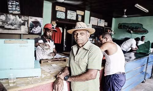 Người dân Cuba đứng nói chuyện tại một cửa hàng tạp hóa.