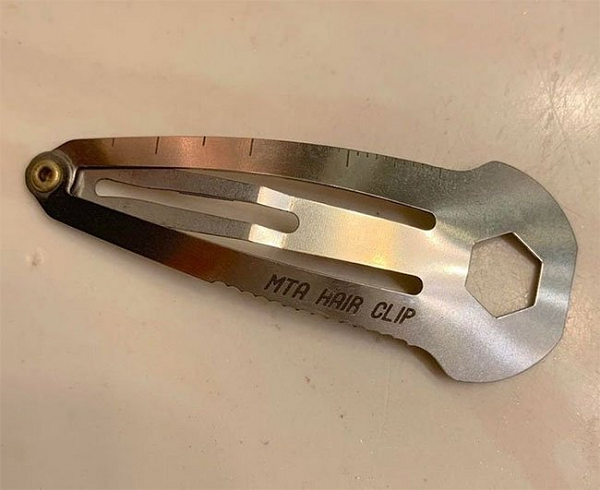 chiếc kẹp tóc đa dụng cụ có một đầu phẳng nhỏ, giống như đinh vít ở phía bên kia khi bạn mở nó.