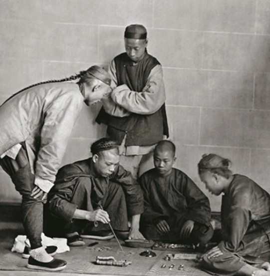 Trong khi đó, một nhóm nam giới chơi bạc.