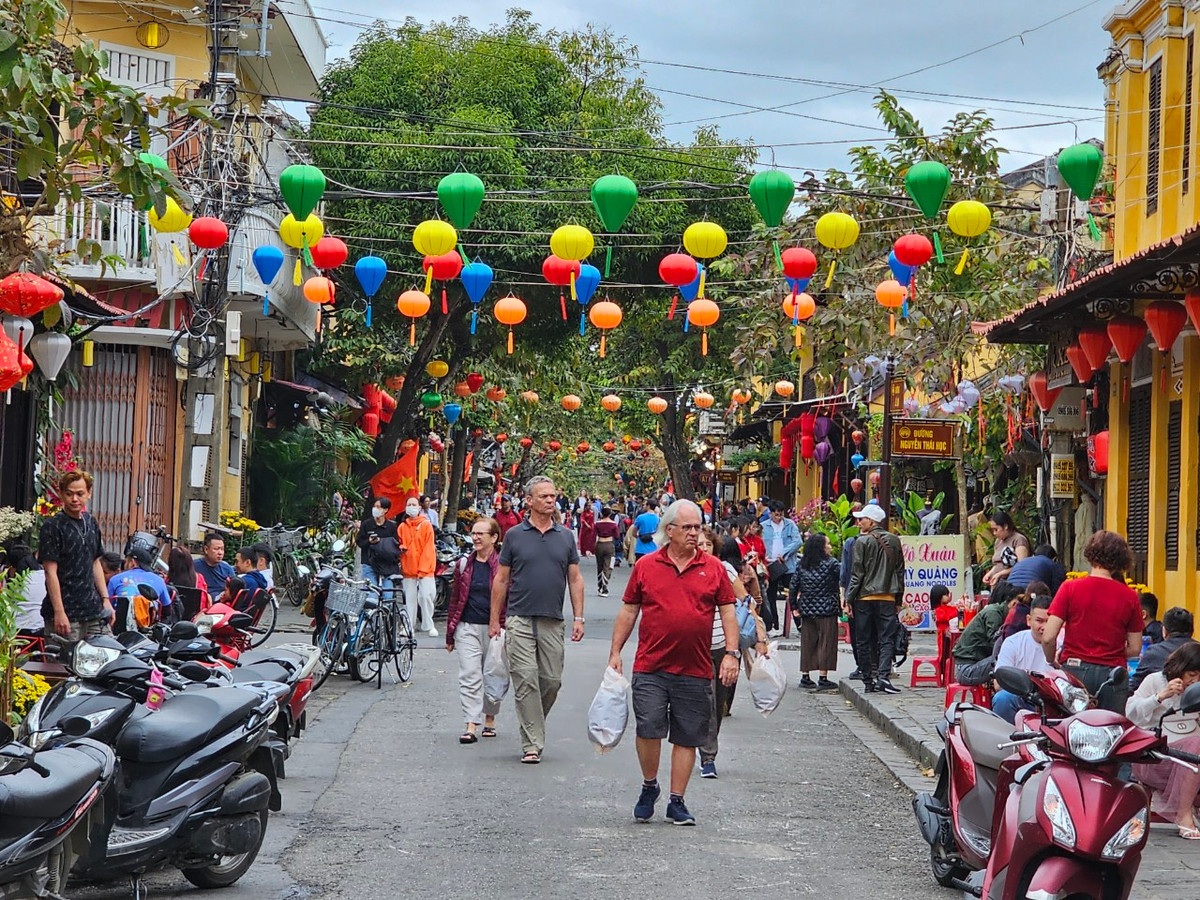 Sáng 10/2, khác hẳn vẻ tĩnh lặng ở nhiều thành phố khác, hàng ngàn lượt khách đổ về TP Hội An để tham quan, du xuân.