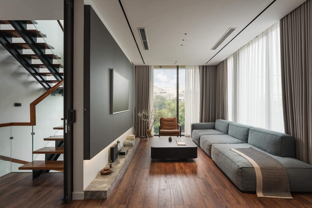 Thay vì sử dụng giếng trời, tận dụng vị trí 2 mặt tiền nhà, KTS sử sụng giải pháp lấy sáng tự nhiên từ hành lang giao thông là tường kính và cầu thang xương cá, cùng với các hệ cửa kính ở cạnh mặt tiền. 